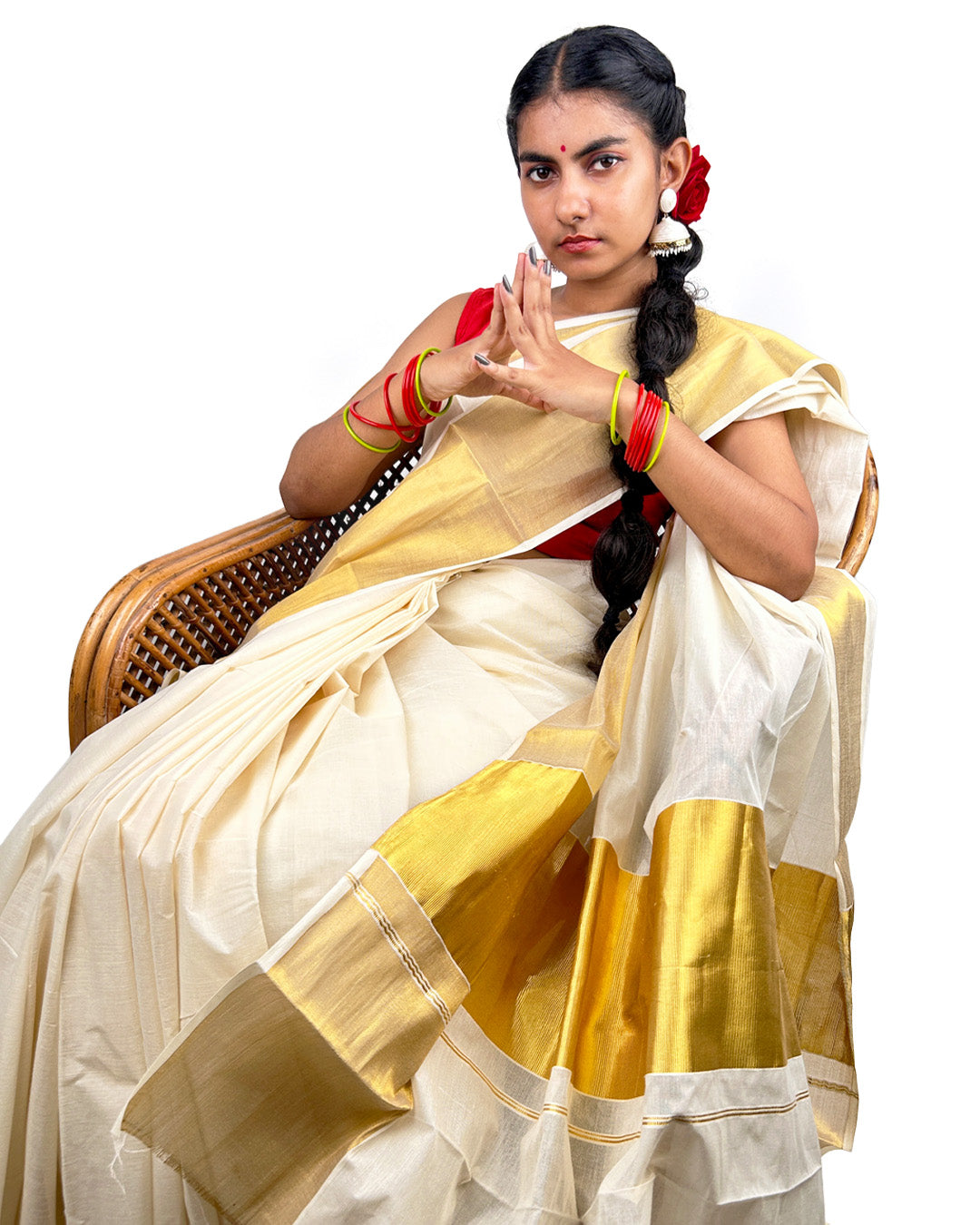 Woman wearing a traditional kerala kasavu  in white and yellow saree with red accessories on a white background