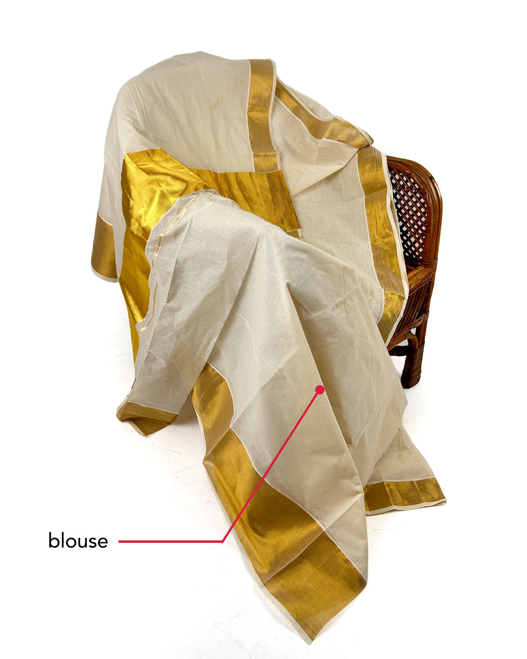 White saree with gold border draped over a chair on a white background