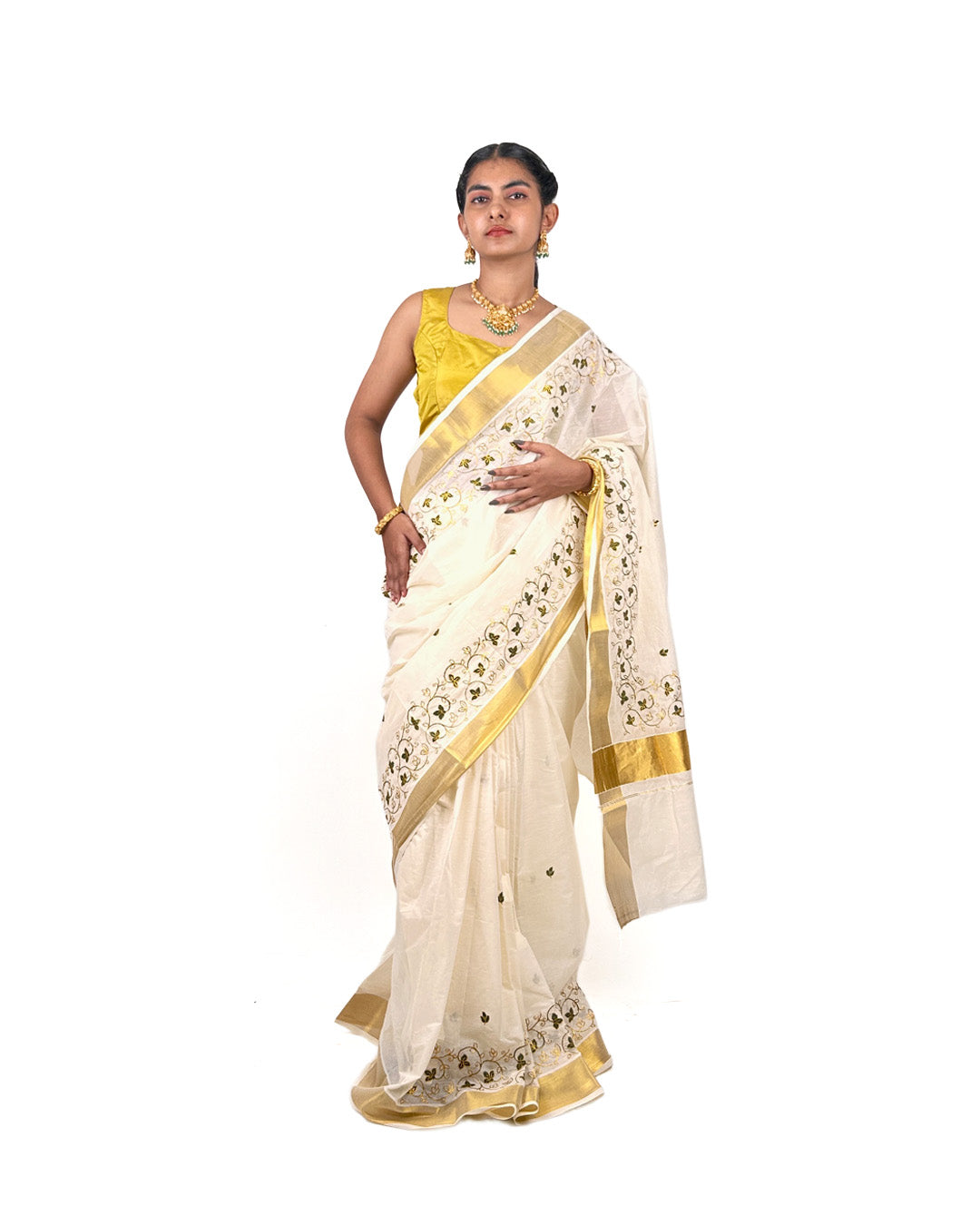 Woman wearing a white saree with gold border with floral vine embroidery and yellow blouse on a white background