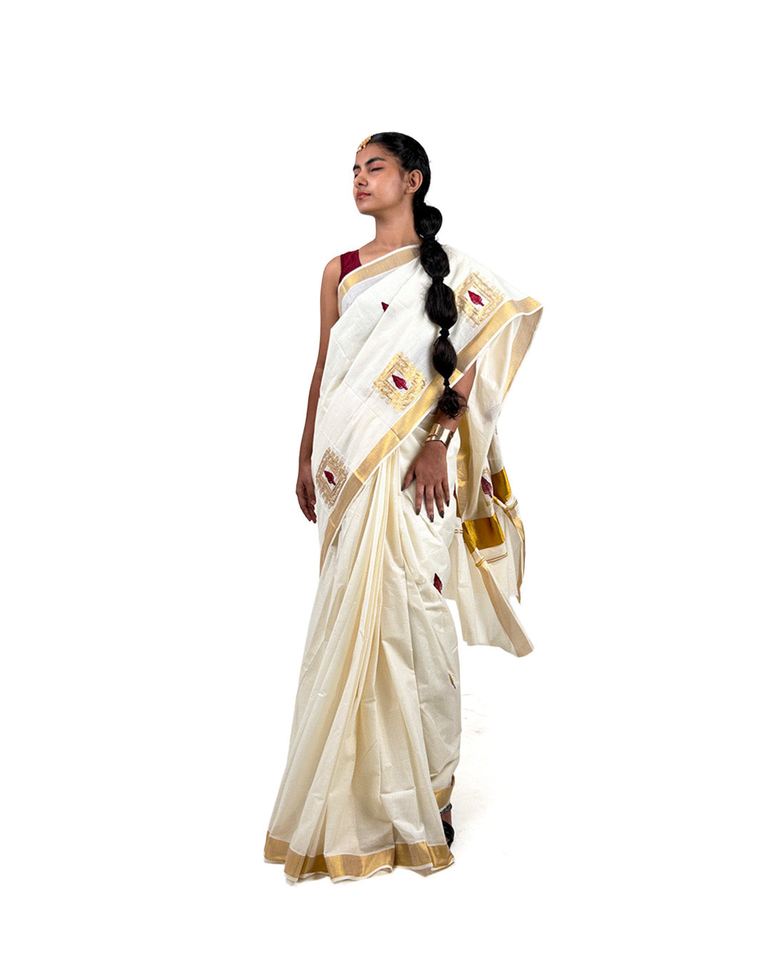 Woman wearing a white kasavu saree with gold border on a white background