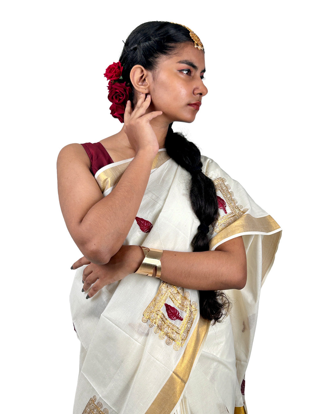 Woman wearing a traditional white kerala saree with gold border and red embroidery details on a white background