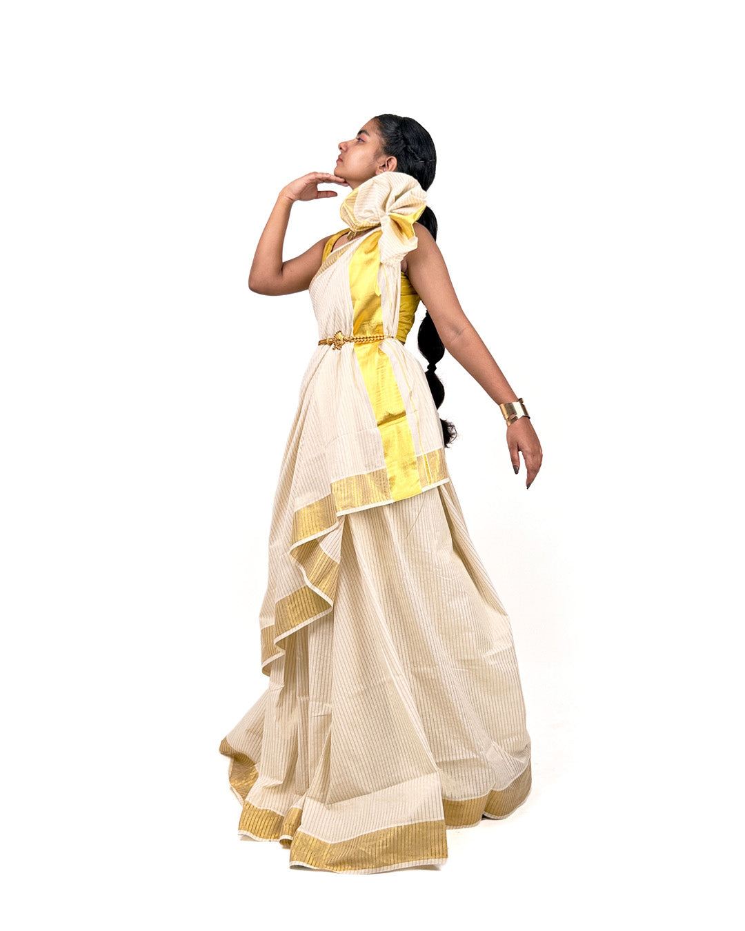 Woman wearing a cream and yellow striped kerala kasavu saree on a white background