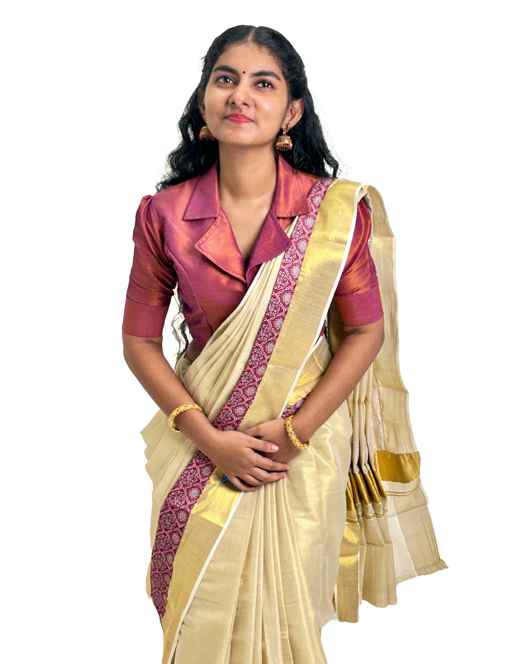 Woman wearing a traditional Kerala kasavu saree with maroon border, styled with a maroon blouse — photographed on a white background. Perfect for Onam, weddings, and festive occasions.